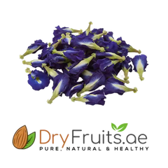 A pile of dried blue butterfly pea flowers with purple-blue petals and pale yellow-green centers, shown above the DryFruits.ae logo on a white background.