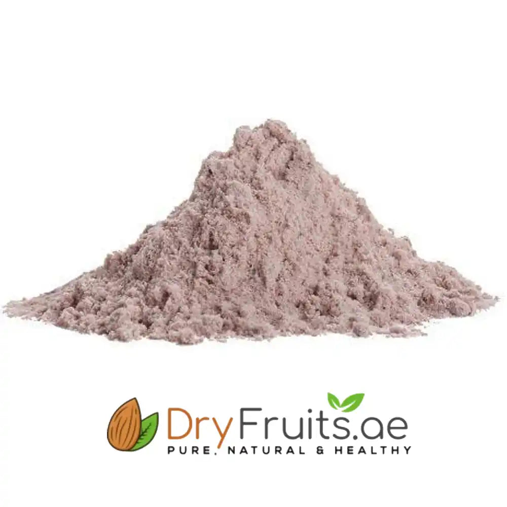 A mound of light brownish-pink powder, likely a fruit or vegetable extract, shown on a white background with the DryFruits.ae brand logo at the bottom.