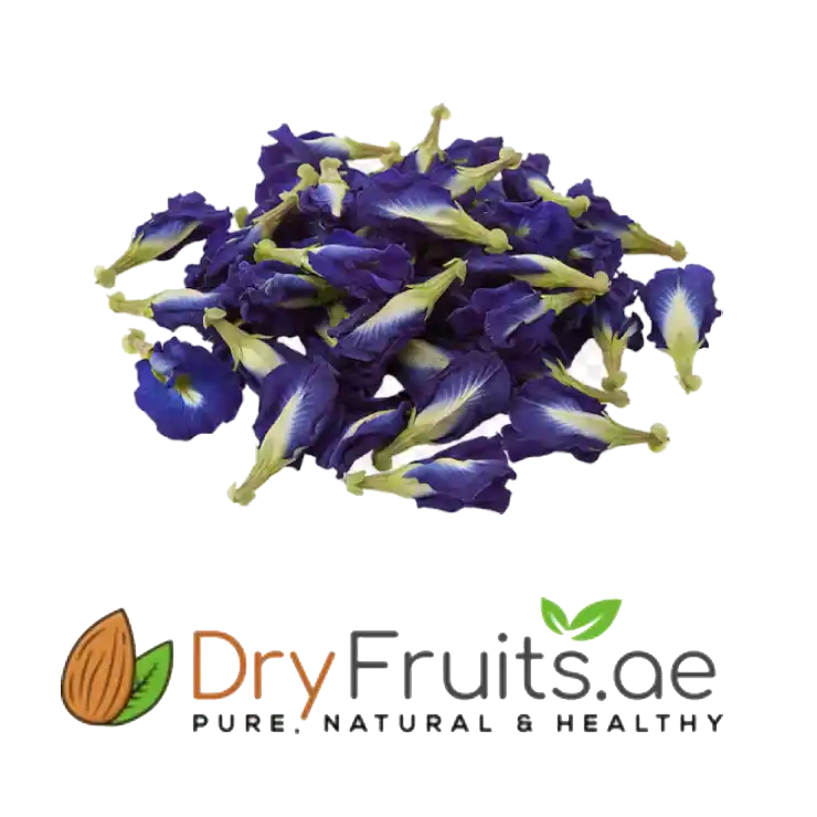 A pile of dried blue butterfly pea flowers with purple-blue petals and pale yellow-green centers, shown above the DryFruits.ae logo on a white background.